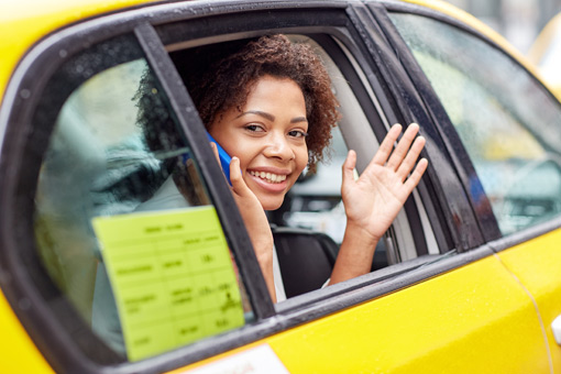 Woman waving hand from taxi